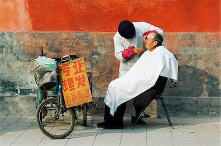 simsearch:862-03351488,k - Chine, Beijing. Un poil de coupe barber en plein air à côté d'un mur de temple. Photographie de stock - Rights-Managed, Code: 862-03351479