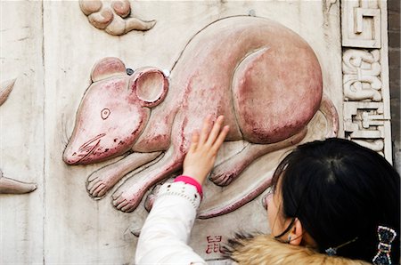 China,Beijing. Chinese New Year Spring Festival - a girl touching a mouse scultpture at Baiyun Guan White Cloud Taoist Temple in the Year of the Rat. Stock Photo - Rights-Managed, Code: 862-03351565