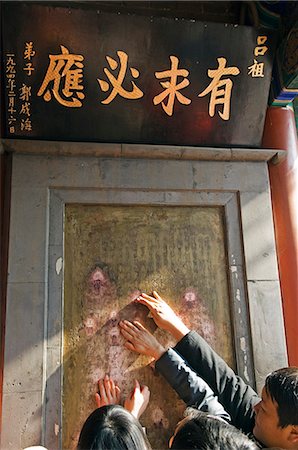 China,Beijing. Chinese New Year Spring Festival - worshippers touching sacred insriptions at Baiyun Guan White Cloud Taoist Temple. Stock Photo - Rights-Managed, Code: 862-03351566