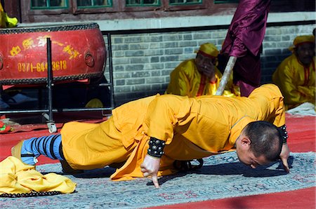 China,Beijing. Beiputuo temple and film studio - Chinese New Year Spring Festival - a monk performing one finger push ups. Stock Photo - Rights-Managed, Code: 862-03351587