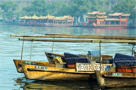 China,Zhejiang Province,Hangzhou. Boats and temple pavilions on the edge of West Lake Stock Photo - Rights-Managed, Code: 862-03351628