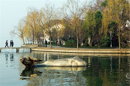 China,Zhejiang Province,Hangzhou. A statue of a golden water buffalo in the waters of West Lake. Stock Photo - Rights-Managed, Code: 862-03351631