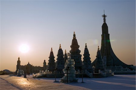 China,Northeast China,Heilongjiang Province,Harbin City. Ice Lantern Festival. Sunset on an ice sculpture replica of Bangkok's Wat Po. Stock Photo - Rights-Managed, Code: 862-03351643