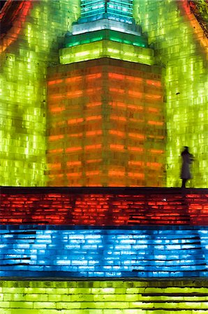 sculpted - China,Northeast China,Heilongjiang Province,Harbin City. Ice Lantern Festival. A lone figure standing on the steps of a colourful ice sculpture illuminated at night. Foto de stock - Con derechos protegidos, Código: 862-03351653