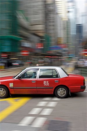 simsearch:862-03351951,k - Chine, Hong Kong. Un taxi de la ville se déplace à la vitesse par l'intermédiaire de l'animé quartier du centre-ville de Hoong Kong island se précipiter pour prendre un passager. Photographie de stock - Rights-Managed, Code: 862-03351938