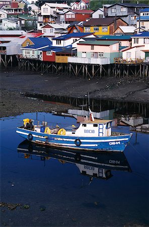 Fishing boat in front of brightly painted palafitos Stock Photo - Rights-Managed, Code: 862-03352089