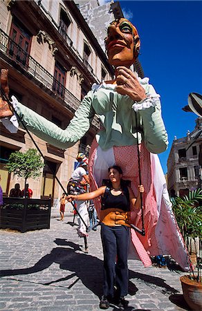 Los Zancudos. Woman standing in front of stilt dancer in old Havana World Heritage Area,Cuba Stock Photo - Rights-Managed, Code: 862-03352457