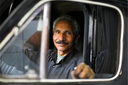 A mechanic sits inside a car at his garage in the district of Zamalek,Cairo,Egypt. Stock Photo - Rights-Managed, Code: 862-03352733