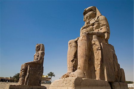 The Colossi of Memnon stand at the entrance to the ancient Theban Necropolis on the West Bank of the Nile at Luxor. Foto de stock - Direito Controlado, Número: 862-03352773