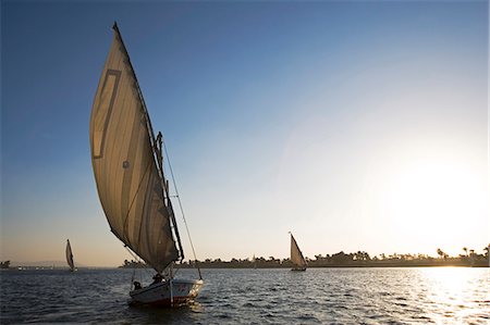 sailboat silhouette - Feluccas silhouetted against the setting sun on the Nile at Luxor,Egypt Stock Photo - Rights-Managed, Code: 862-03352793