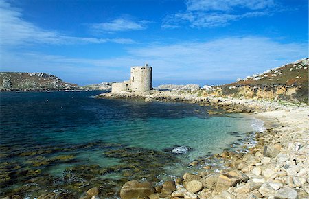 seaside ruin - A view of Cromwell's Castle,which guards the northern approaches to New Grimsby Harbour. Cromwell's Castle is a stone 17th century circular artillery tower,with a low 18th century gun platform,that has its own access and guard room. Stock Photo - Rights-Managed, Code: 862-03353029