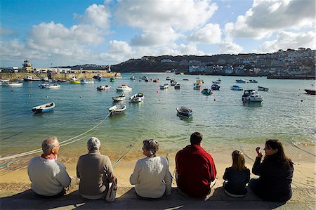 saint ives - Eine Gruppe Touristen plaudern und essen Eis beim Sitzen auf dem Kai in St Ives, Cornwall. Stockbilder - Lizenzpflichtiges, Bildnummer: 862-03353060