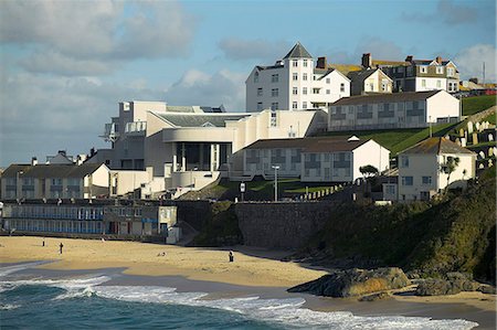 english ports - The Tate St Ives,the provincial outpost of the famous London art gallery built in 1993,standing above Porthmeor Beach. Artists such as Barbera Hepworth and Alfred Wallace established a thriving artists' colony here in the 1920s and 1930s. The tradition still lives on today with small art galleries and artists' studios scattered around he town. Stock Photo - Rights-Managed, Code: 862-03353061