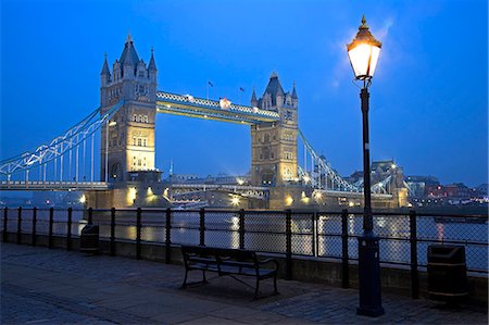 simsearch:862-03353252,k - Tower Bridge by night. Construction of the bridge started in 1886 and took 8 years. The central span can be raised to allow ships to travel upriver. The bridge is close to the Tower of London,which gives it its name. It is often mistaken for London Bridge,the next bridge upstream. Foto de stock - Con derechos protegidos, Código: 862-03353108