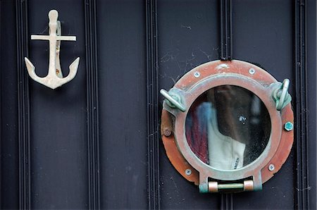 La porte de la maison de pêcheur à Mousehole a un point d'ancrage pour un heurtoir de porte et le hublot d'un navire pour un Judas, Cornouailles, Angleterre Photographie de stock - Rights-Managed, Code: 862-03353335