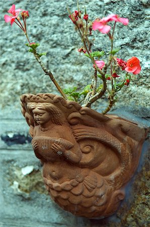 A terracotta flower pot cast in the shape of a mermaid adorns a fisherman's cottage in Mousehole,Cornwall,England Foto de stock - Con derechos protegidos, Código: 862-03353336