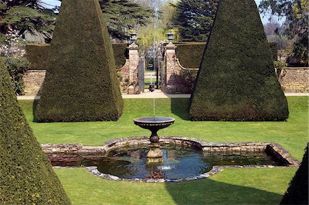 Angleterre, Dorset. Athelhampton House est l'un des plus beaux exemples d'architecture domestique du XVe siècle dans le pays. Médiéval en style principalement et entouré de murs, de l'eau caractéristiques et tribunaux isolée. Ici l'art topiaire de la grande cour est un chef-d'oeuvre de Francis Inigo Thomas. Photographie de stock - Rights-Managed, Code: 862-03353621