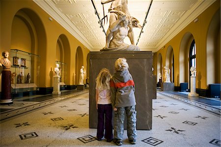 Angleterre, Londres, Victoria and Albert Museum. Un frère et une sœur regarder en haut une statue classique sculptée dans l'une galerie Regarde un de l'un des plus importants centres d'accueil du monde. . Photographie de stock - Rights-Managed, Code: 862-03353650