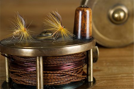 reel - England. Dry flies on a traditional brass fly fishing reel. Stock Photo - Rights-Managed, Code: 862-03353749