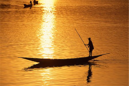 staken - Boatman punting his boat from the stern at sunset on the Niger River Foto de stock - Con derechos protegidos, Código: 862-03364076