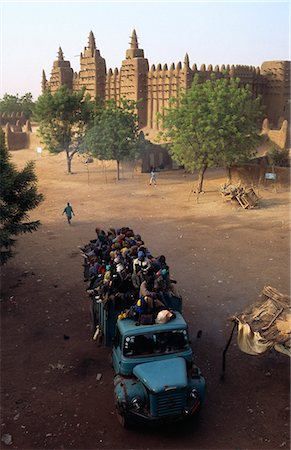 Passengers cram the top of a packed camion leaving the ancient trading city of Djenne after the Monday Market. The city comes alive with the famous market at the foot of the Grand Mosque Foto de stock - Con derechos protegidos, Código: 862-03364113