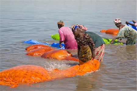 Mali, Bamako. Rinçage brillamment coloré chiffon de coton dans le fleuve Niger, à la périphérie de Bamako, après teinture il. Photographie de stock - Rights-Managed, Code: 862-03364120