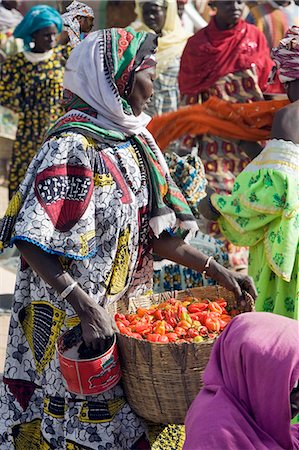 Mali, Djenné. Une femme porte un panier de piments rouges au marché de Djenné. Le marché hebdomadaire du lundi est se pressaient des milliers de personnes et est l'un des plus colorés en Afrique de l'Ouest. Photographie de stock - Rights-Managed, Code: 862-03364141