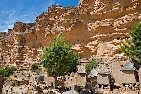 simsearch:400-04925770,k - Mali,Dogon Country,Tereli. The typical Dogon village of Tereli situated among rocks at the base of the 120-mile-long Bandiagara escarpment. Dwellings have flat roofs while granaries to store millet have pitched thatched roofs. Foto de stock - Con derechos protegidos, Código: 862-03364197