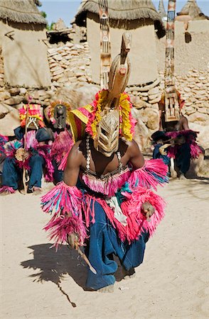 simsearch:862-03364124,k - Au Mali, pays Dogon, ce. Un danseur masqué effectue dans le village Dogon de ce. C'est situé parmi les rochers au pied de l'escarpement de Bandiagara spectaculaire 120 milles de longueur. La danse des masques est mis en scène lors des cérémonies funéraires pour apaiser les morts et leur vitesse en route vers le monde ancestral. Photographie de stock - Rights-Managed, Code: 862-03364208