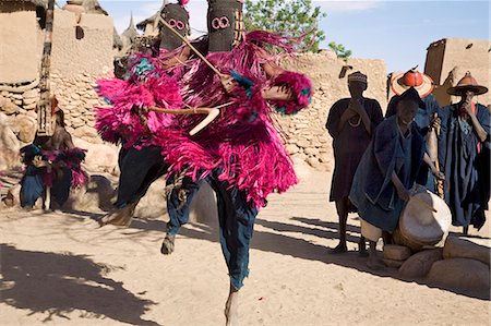 simsearch:851-02962761,k - Au Mali, pays Dogon, ce. Danseurs masqués sautent en l'air dans le village Dogon de ce qui se trouve parmi les rochers au pied de l'escarpement de Bandiagara spectaculaire 120 milles de longueur. La danse de masque est exécutée lors de cérémonies funéraires pour apaiser les morts et leur vitesse en route vers le monde ancestral. Photographie de stock - Rights-Managed, Code: 862-03364200