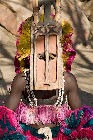 simsearch:862-03737290,k - Au Mali, pays Dogon, ce. Les yeux perçants d'un danseur masqué portant le masque Sirige de quinze pieds de hauteur au village Dogon de ce qui se trouve parmi les rochers au pied de l'escarpement de Bandiagara spectaculaire 120 milles de long. La danse des masques est mis en scène lors des cérémonies funéraires pour apaiser les morts et leur vitesse en route vers le monde ancestral. Photographie de stock - Rights-Managed, Code: 862-03364203