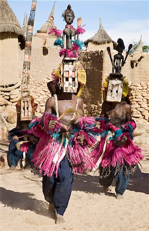 people in africa clothes colors - Mali,Dogon Country,Tereli. Masked dancers wearing the satimbe mask perform at the Dogon village of Tereli. This mask honours the primordial woman who is said to have discovered the original Dogon masks. The mask dance is staged at funeral ceremonies to appease the dead and speed them on their way to the ancestral world. Stock Photo - Rights-Managed, Code: 862-03364211