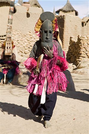 simsearch:862-03737290,k - Au Mali, pays Dogon, ce. Un danseur masqué effectue dans le village Dogon de ce. C'est situé parmi les rochers au pied de l'escarpement de Bandiagara spectaculaire 120 milles de longueur. La danse des masques est mis en scène lors des cérémonies funéraires pour apaiser les morts et leur vitesse en route vers le monde ancestral. Photographie de stock - Rights-Managed, Code: 862-03364213