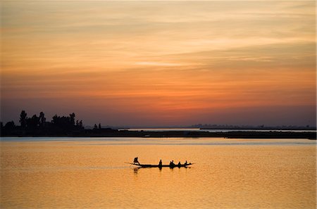 Mali, Mopti. Au coucher du soleil, un batelier dans une pirogue ferries passagers sur le fleuve Niger à Mopti. Photographie de stock - Rights-Managed, Code: 862-03364220