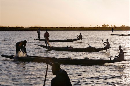 pirogue - Mali, Delta intérieur du Niger. Au crépuscule, les pêcheurs Bozo pêcher avec des filets dans le fleuve Niger au nord de Mopti. Photographie de stock - Rights-Managed, Code: 862-03364274