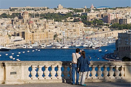 simsearch:862-03354545,k - Malta,Valletta. Tourists look out from an elegant ballustrade on the old walls of Valletta over the Grand Harbour towards Vittoriosa. Foto de stock - Direito Controlado, Número: 862-03364503