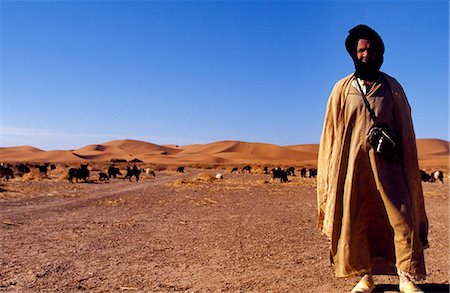 Berber goat herder on plains at foot of Erg Chegaga,Sahara,Southern Morocco. Stock Photo - Rights-Managed, Code: 862-03364609