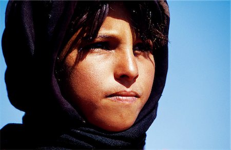 Young Berber girl in dark head cloth looking into distance,Sahara,Southern Morocco. Stock Photo - Rights-Managed, Code: 862-03364611