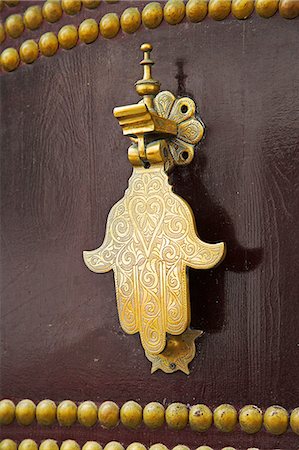 La main de Fatima, sur une porte en bois traditionnelle à la kasbah de Tanger, le point culminant de la ville. La main protège la maison contre le mauvais œil. Photographie de stock - Rights-Managed, Code: 862-03364698