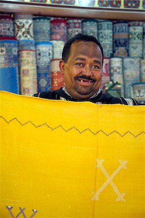 A carpet salesman displays his wares in the souq of Marrakesh Foto de stock - Con derechos protegidos, Código: 862-03364726