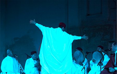 fez - Maroc, Fes. Un danseur soufi se met en transe lors du Concert de Hadhra dans le Fes Festival de musiques sacrées du monde. Lufti Bushnaq (soliste) est à l'extrême droite de l'image. Photographie de stock - Rights-Managed, Code: 862-03364818