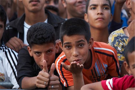 Morocco,Fes. Two boys in the crowd at a concert during the Fes Festival of World Sacred Music blow kisses. Fotografie stock - Rights-Managed, Codice: 862-03364811