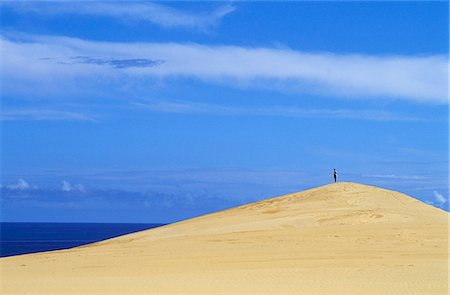 Un touriste se dresse au sommet d'une dune de sable sur l'île de Benguerra face à l'océan Indien Photographie de stock - Rights-Managed, Code: 862-03364879