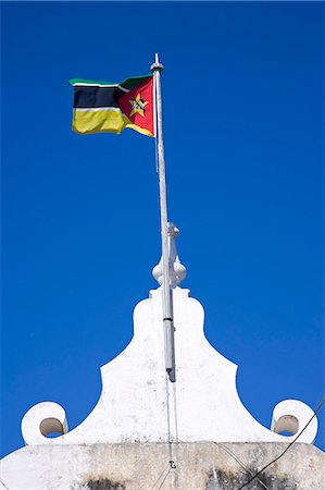 A Mozambique flag flies over the naval museum housed in an old colonial building on Ilha do Mozambique,the former capital of Portuguese East Africa Stock Photo - Rights-Managed, Code: 862-03364956
