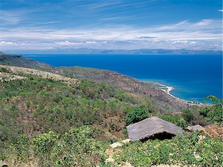 Une belle vue du lac Malawi, prise depuis la route menant vers le bas de l'escarpement de la vallée du Rift au collier. Les collines lointaines sont en Mozambique.Lake au Malawi est la quintessence d'un lac de la vallée du Rift, longue, étroite et peu profonde. 363 km de long et qui couvre un cinquième du Malawi, il a une faune de poissons plus diversifiée que tous les autres lacs dans le monde... Photographie de stock - Rights-Managed, Code: 862-03365067