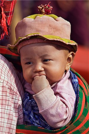 pompón - Myanmar,Burma,Lake Inle. A Pa-O child carried on her mother’s back at Indein market. Foto de stock - Con derechos protegidos, Código: 862-03365180