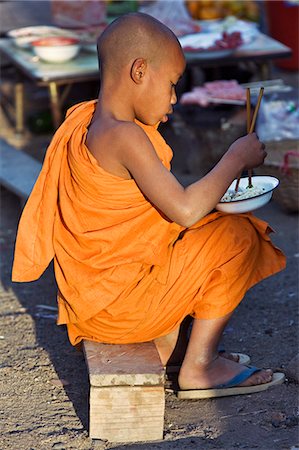 Myanmar. Burma. Wanpauk village. A novice monk eating noodles with chopsticks at Wanpauk village market. Foto de stock - Con derechos protegidos, Código: 862-03365198