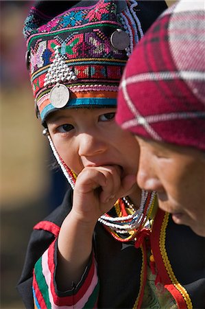 peto - Myanmar,Burma,Kengtung. A young Akha boy wearing a colourful embroidered hat while carried by his mother. Foto de stock - Con derechos protegidos, Código: 862-03365225