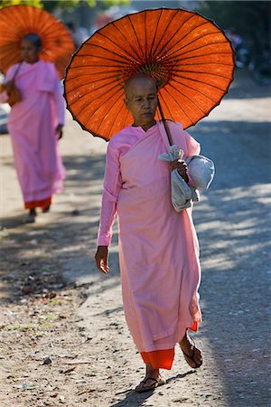 Myanmar,Burma,Sittwe. Buddhist nuns with traditional bamboo-framed orange umbrellas walk through the streets of Sittwe. Stock Photo - Rights-Managed, Code: 862-03365265