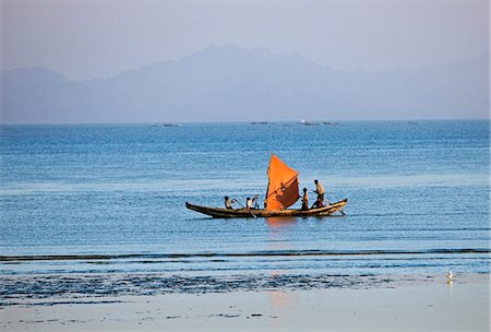 Myanmar,Burma,Rakhine State. As the sun sets after a blistering day,the crew of a small fishing boat hurries home to Sittwe harbour with their catch. Stock Photo - Rights-Managed, Code: 862-03365270